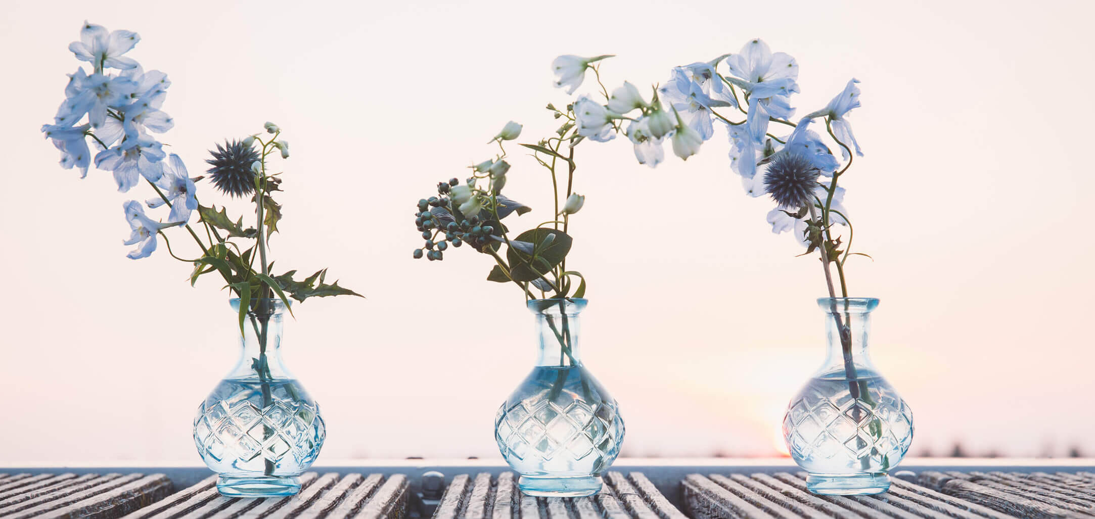 Drei blaue Vasen mit blauen Blumen.